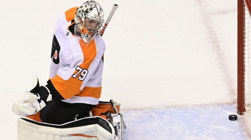 "Flyers" vārtsargs Kārters Hārts noskatās, kā ripa lēnām ieslīd vārtos pēc Leo Komarova metiena. Foto: The Canadian Press/PA Images/Scanpix