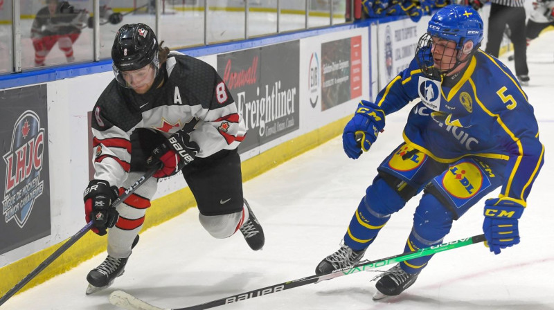 Kanādietis Breks Makkinlijs cīņā pret zviedru Tomu Villanderu. Foto: Robert Lefebvre/Hockey Canada Images