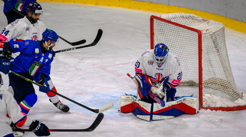 Lielbritānijas valstsvienības kanādiešu vārtsargs Mets Robsons tver Itālijas hokejista raidīto ripu. Foto: Matteo Canevari